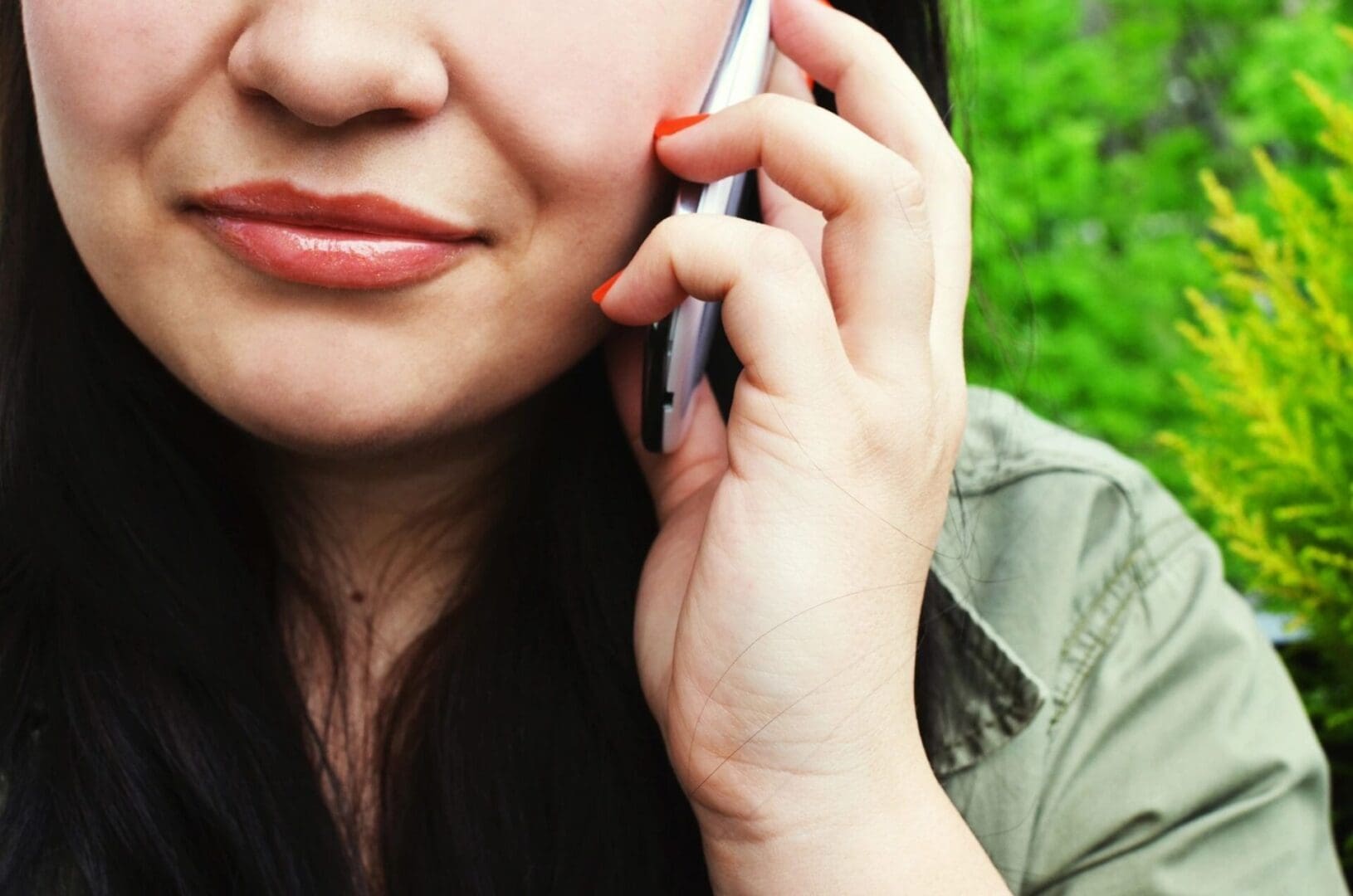 A woman holding her cell phone to her ear.